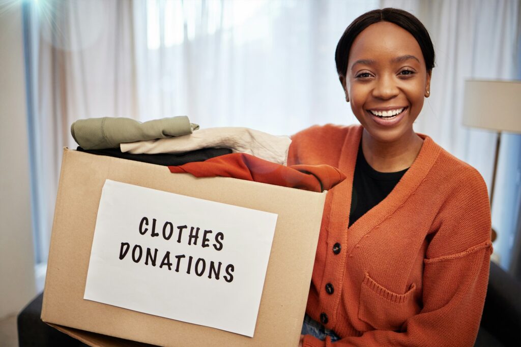 Clothes donation, charity and woman portrait with box for nonprofit and cardboard container at home